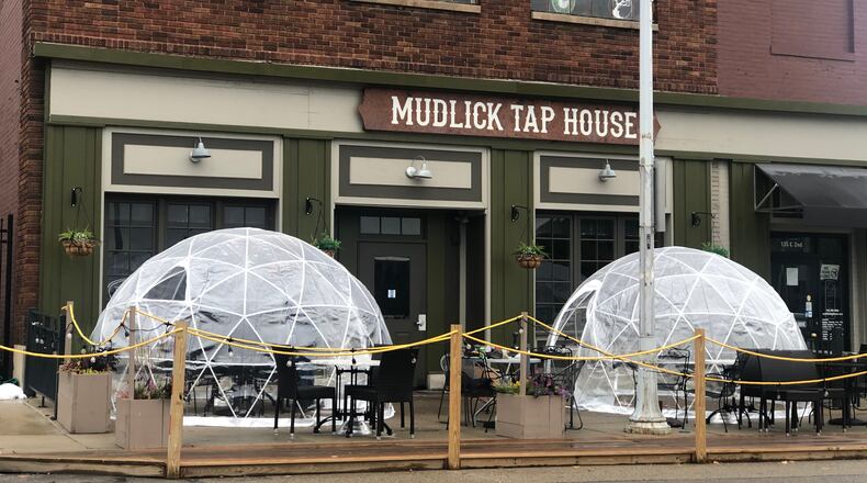 Mudlick Tap House in downtown Dayton installed plastic igloos on its patio to keep guests safe during the pandemic. CORNELIUS FROLIK / STAFF