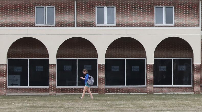 A student at Urbana University walks past the arches on one of the residence hall as she makes her way across campus Monday, March 26, 2018. Bill Lackey/Staff