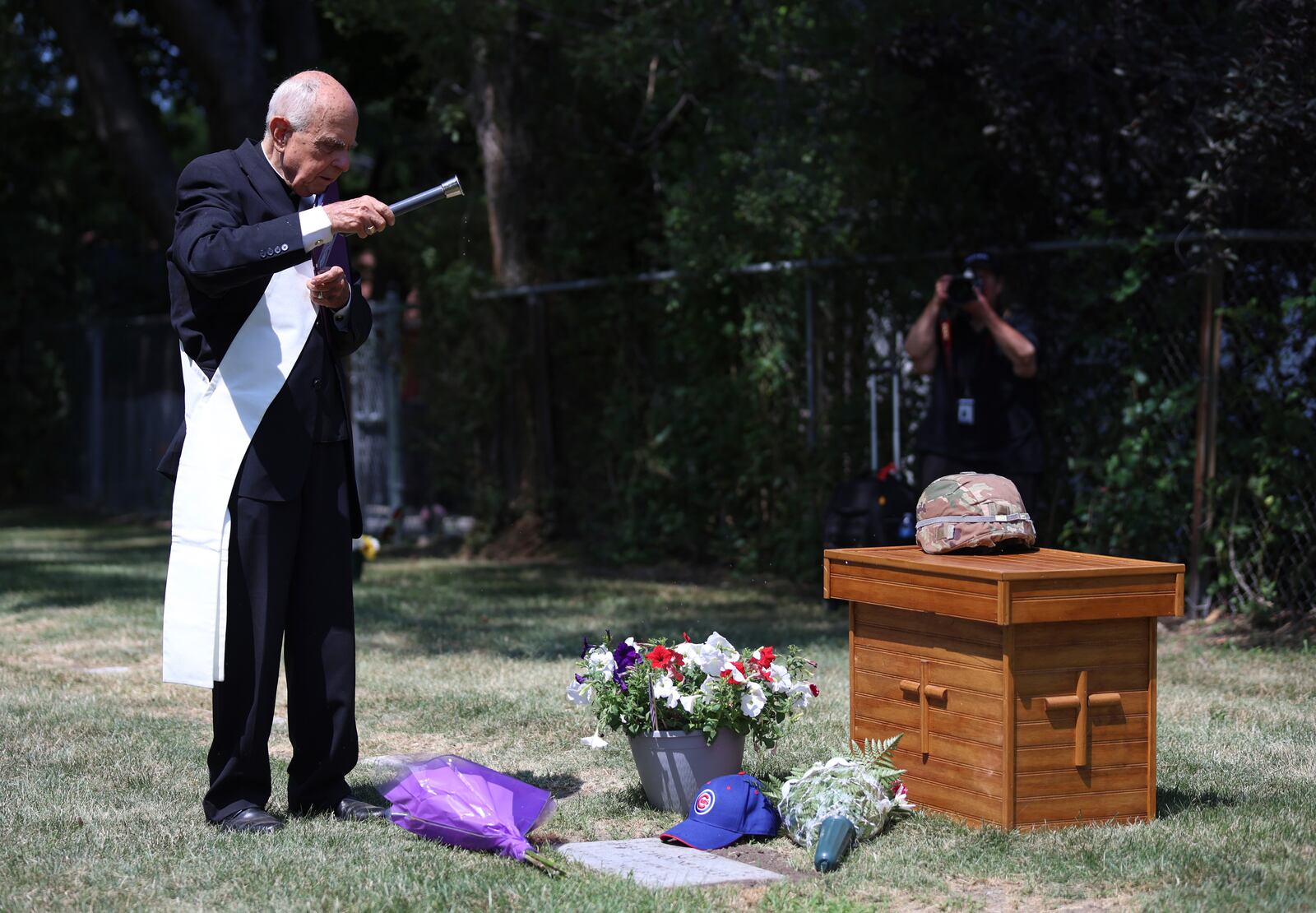 Deacon Glenn Tylutki, of Chicago Catholic Cemeteries, blesses the grave of 75-year-old Pfc. Reba C. Bailey, a former missing person cold case named Seven Doe, during a military funeral Tuesday, July 1, 2025, at Mount Olivet Catholic Cemetery in Chicago. (AP Photo/Talia Sprague)