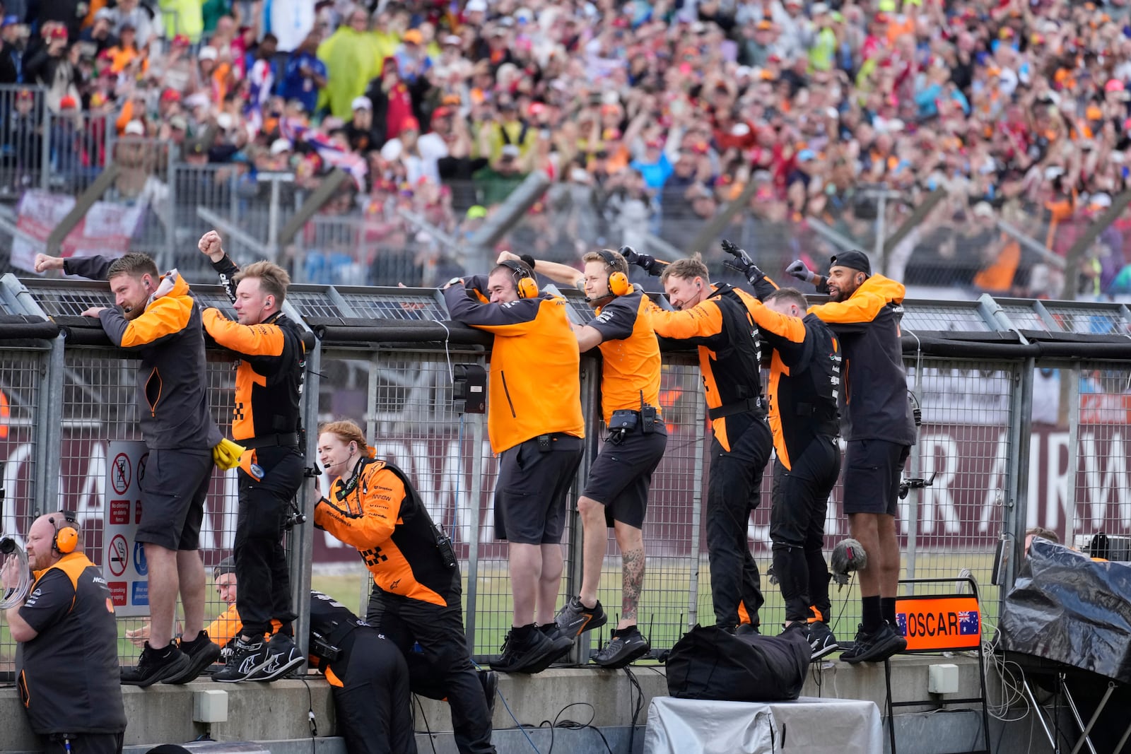 Team members cheer for McLaren driver Lando Norris of Britain as he wins the British Formula One Grand Prix race at the Silverstone racetrack in Silverstone, England, Sunday, July 6, 2025. (AP Photo/Darko Bandic)