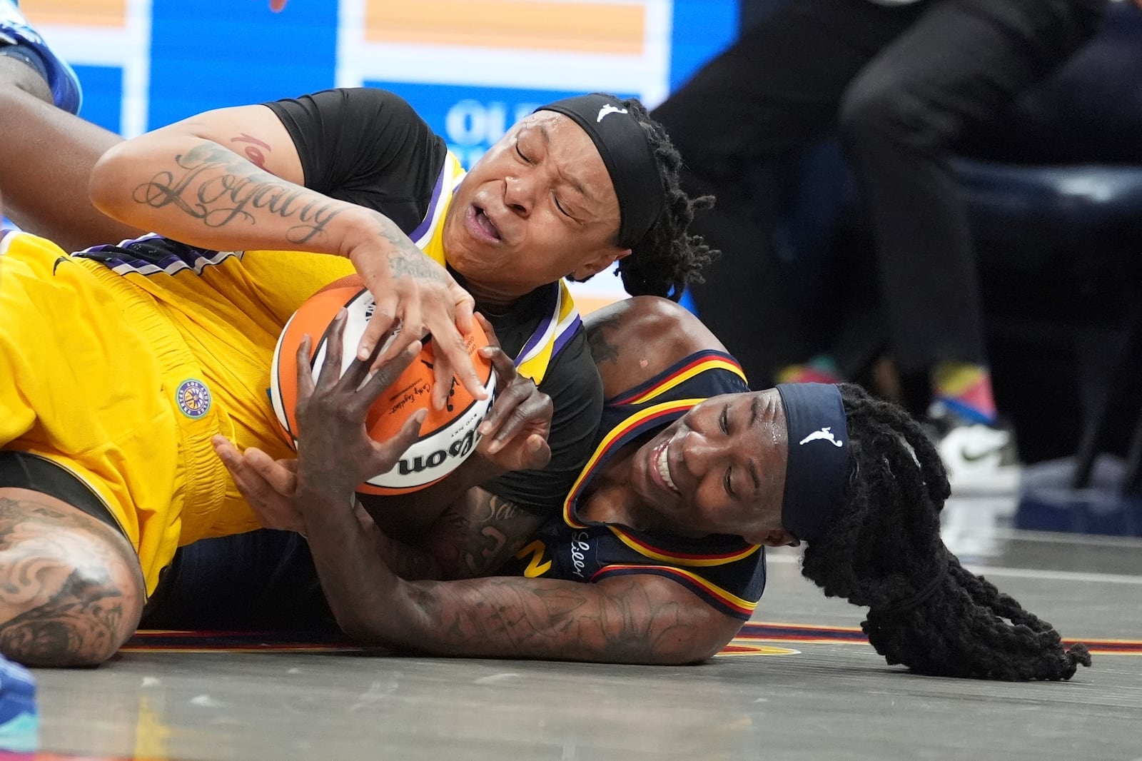 Los Angeles Sparks' Emma Cannon (32) and Indiana Fever's Natasha Howard (6) batlle for a loose ball during the second half of a WNBA basketball game, Saturday, July 5, 2025, in Indianapolis. (AP Photo/Michael Conroy)