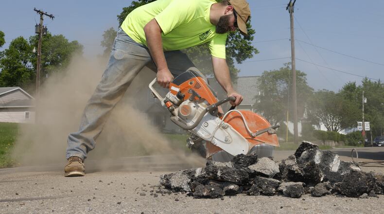 City of Urbana worker Tyler Ohmeiss uses a saw to work on Laurel Oak Street on Thursday, May 15, 2025, in Urbana as part of street improvement as part of a previous city construction project. JOSEPH COOKE/STAFF