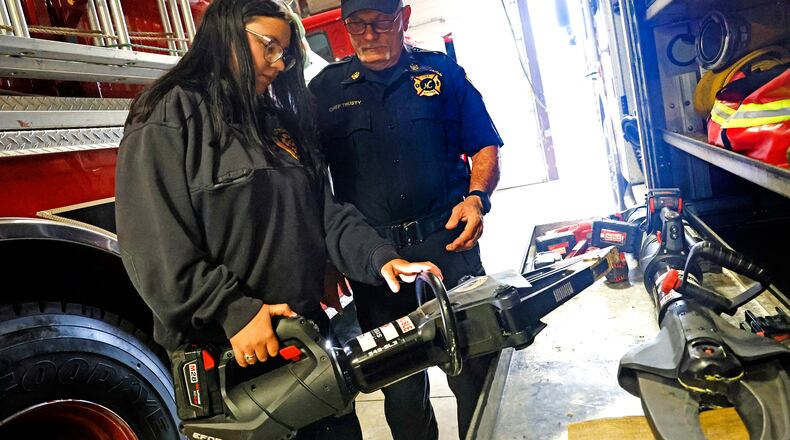Riayn Lowrey, the New Carlisle Fire Department's newest recruit, looks over the equipment with Chief Steven Trusty on Thursday, Sept. 7, 2023. BILL LACKEY/STAFF