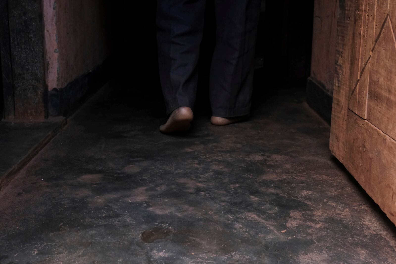 Simon Tigawalana walks into his house with some clay-based earthen floors by EarthEnable on May 16, 2025, in Jinja, Uganda. (AP Photo/Hajarah Nalwadda)