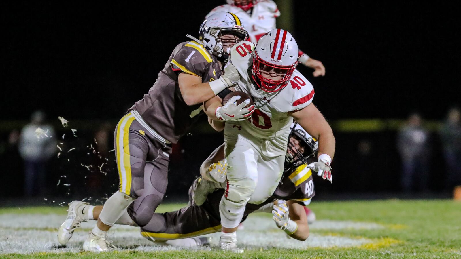 Kenton Ridge High School senior Seven Vannoy (1) and sophomore Brennan Shaffer (40) tackle London senior Noah Sollars during their game at Richard L. Phillips Field in Springfield. The Red Raiders won 42-7. CONTRIBUTED PHOTO BY MICHAEL COOPER