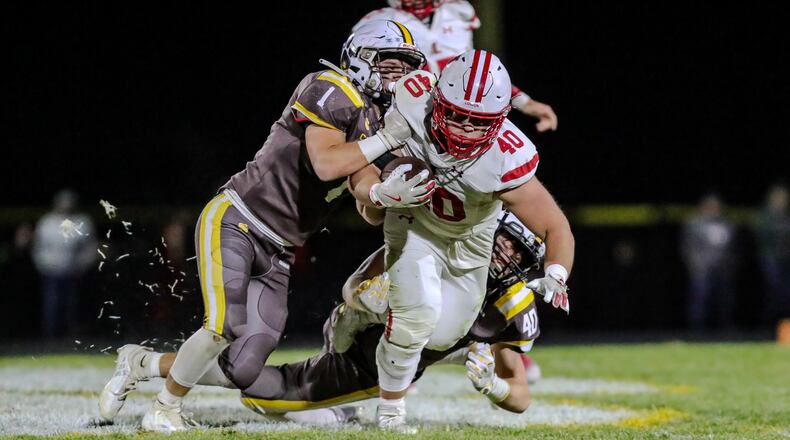Kenton Ridge High School senior Seven Vannoy (1) and sophomore Brennan Shaffer (40) tackle London senior Noah Sollars during their game on Friday night at Richard L. Phillips Field in Springfield. The Red Raiders won 42-7. CONTRIBUTED PHOTO BY MICHAEL COOPER