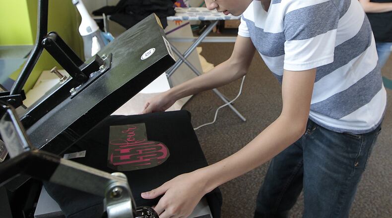 John Koveleski, one of the entrepreneur students, makes a customer’s shirt Thursday, July 20, at The Dome in Springfield. Bill Lackey/Staff
