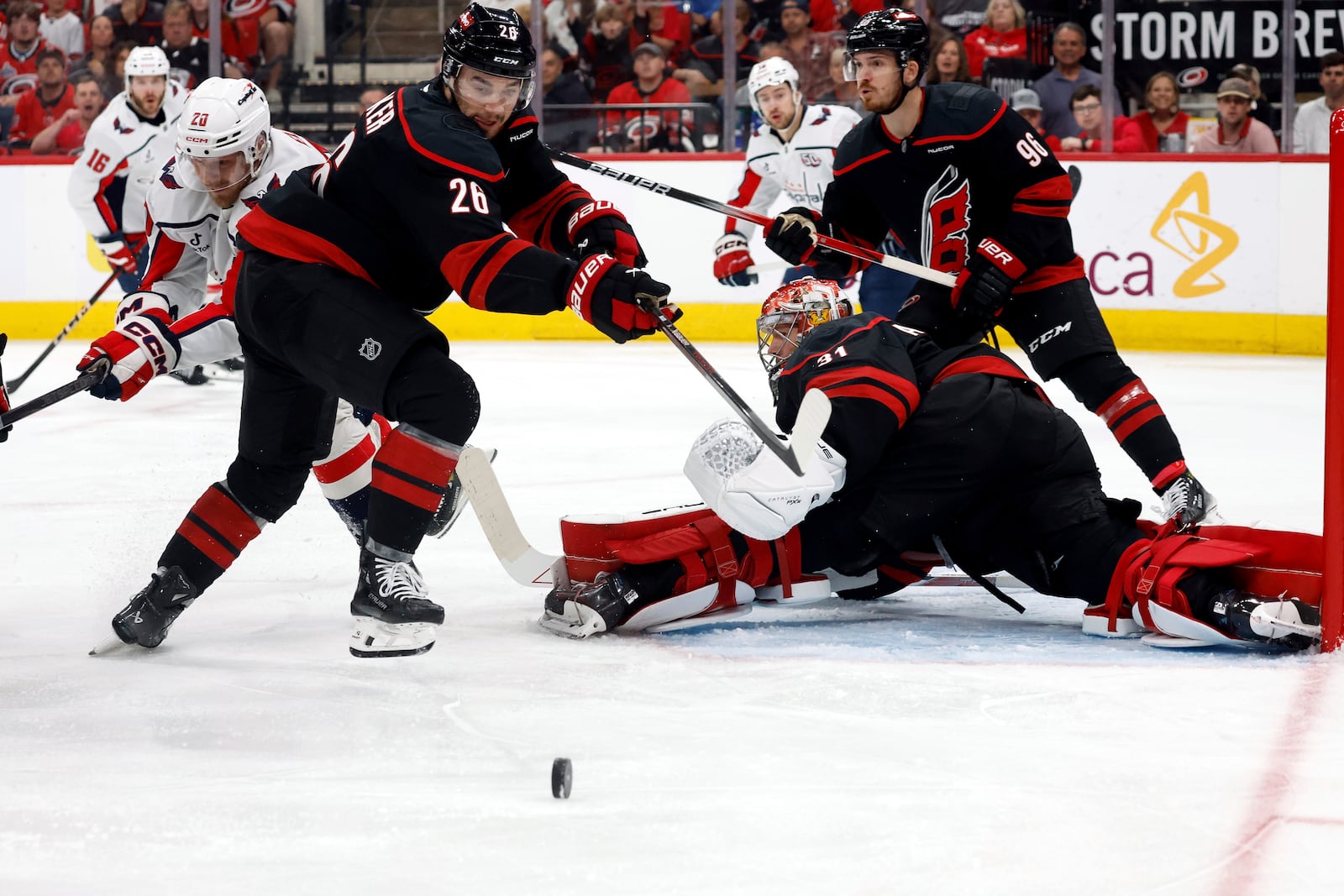 Carolina Hurricanes' Sean Walker (26) clears the puck away from goaltender Frederik Andersen (31) and Washington Capitals' Lars Eller (20) during the first period of Game 3 of an NHL hockey Semi-final round playoff series in Raleigh, N.C., Saturday, May 10, 2025. (AP Photo/Karl DeBlaker)