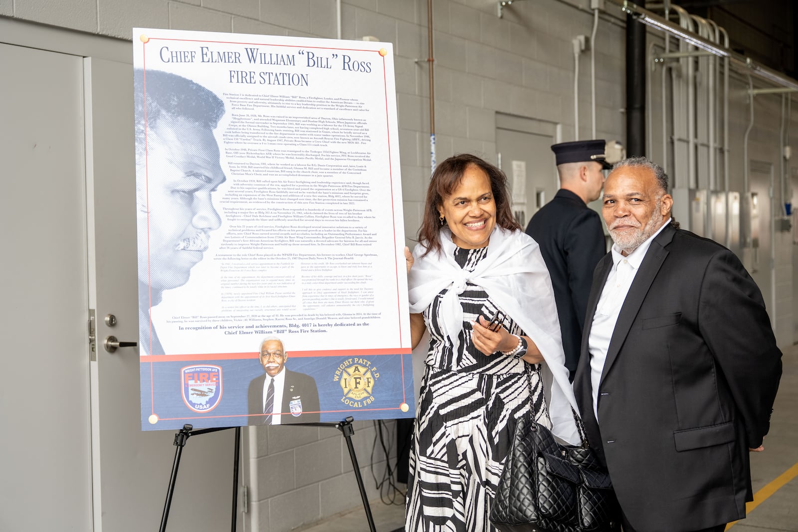 Steve and Angie Ross, two of Bill Ross’s three children (daughter Vickie was at her home in Texas dealing with health issues) with part of an exhibit dedicated to their dad. The exhibit will stand in the bay of the new fire station at Wright Patterson Air Force Base that Saturday was named the Elmer “Bill” Ross Fire Station 2. WRIGHT-PATT AFB / CONTRIBUTED PHOTO