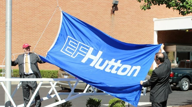 Chris Daniels and John Daniels of EF Hutton America raised its flag outside of its newly-renamed EF Hutton Tower at One Main Street on Sept. 2. The company is expected to bring 400 jobs to Springfield. MICHAEL COOPER/STAFF
