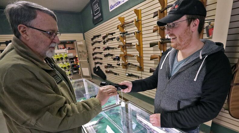 Kevin O’Sullivan, right, shows Phil Judy a hand gun at Delta Armory in Urbana Thursday. BILL LACKEY/STAFF