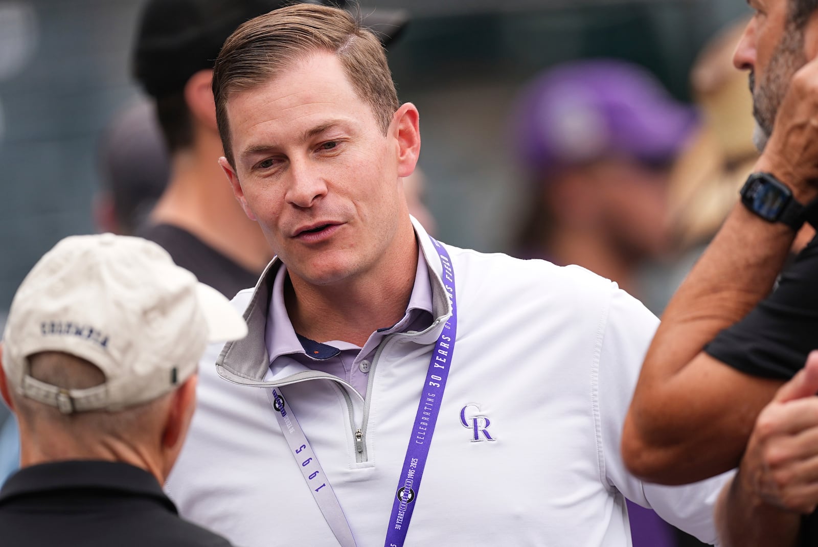 Walker Monfort, the Colorado Rockies vice president of corporate sponsorships, talks with onlookers before a baseball game against the Los Angeles Dodgers, Wednesday, June 25, 2025, in Denver. (AP Photo/David Zalubowski)