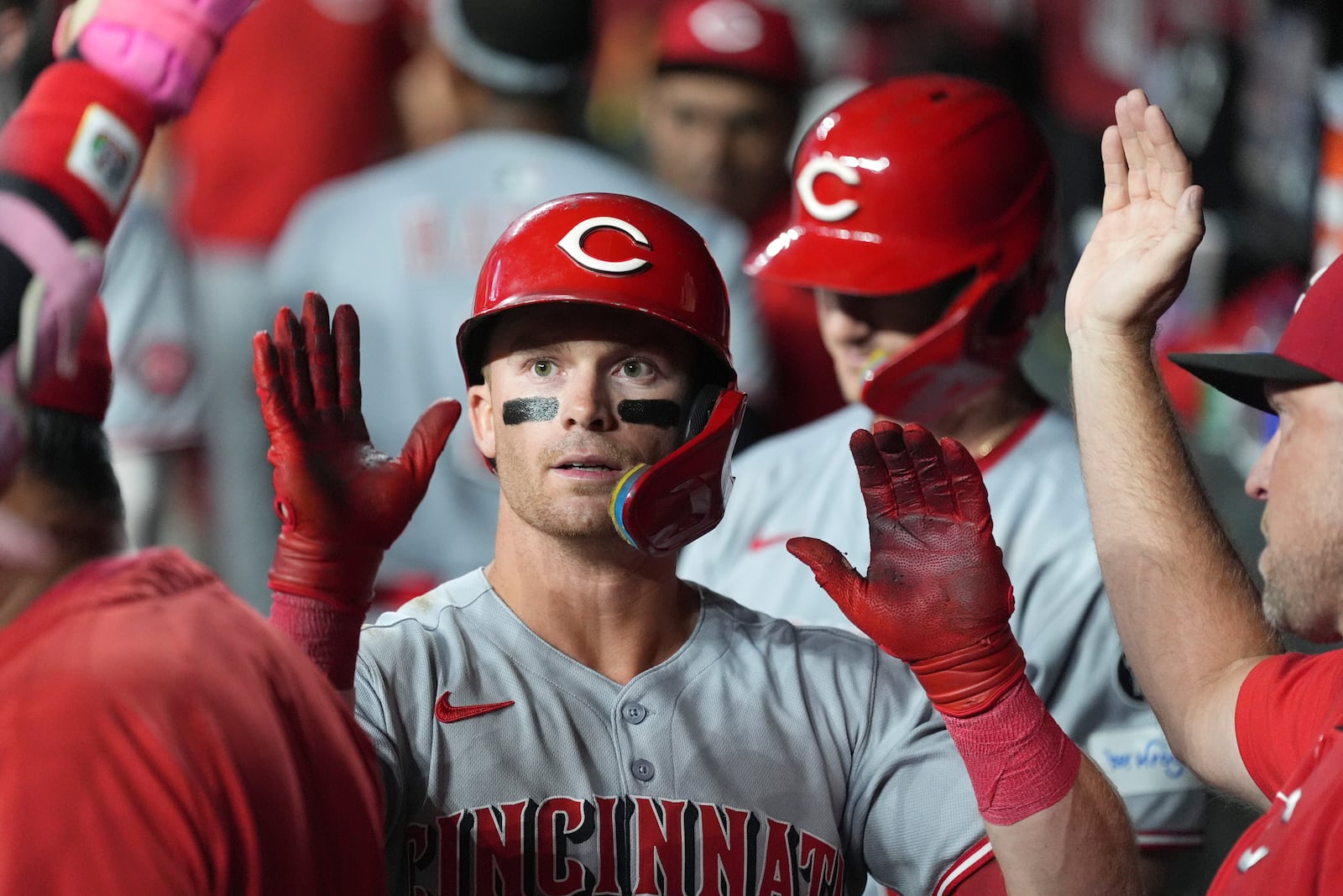 Cincinnati Reds' Matt McLain is congratulated by teammates on his sacrifice bunt against the Arizona Diamondbacks during the 10th inning of a baseball game Friday, Aug. 22, 2025, in Phoenix. (AP Photo/Ross D. Franklin)