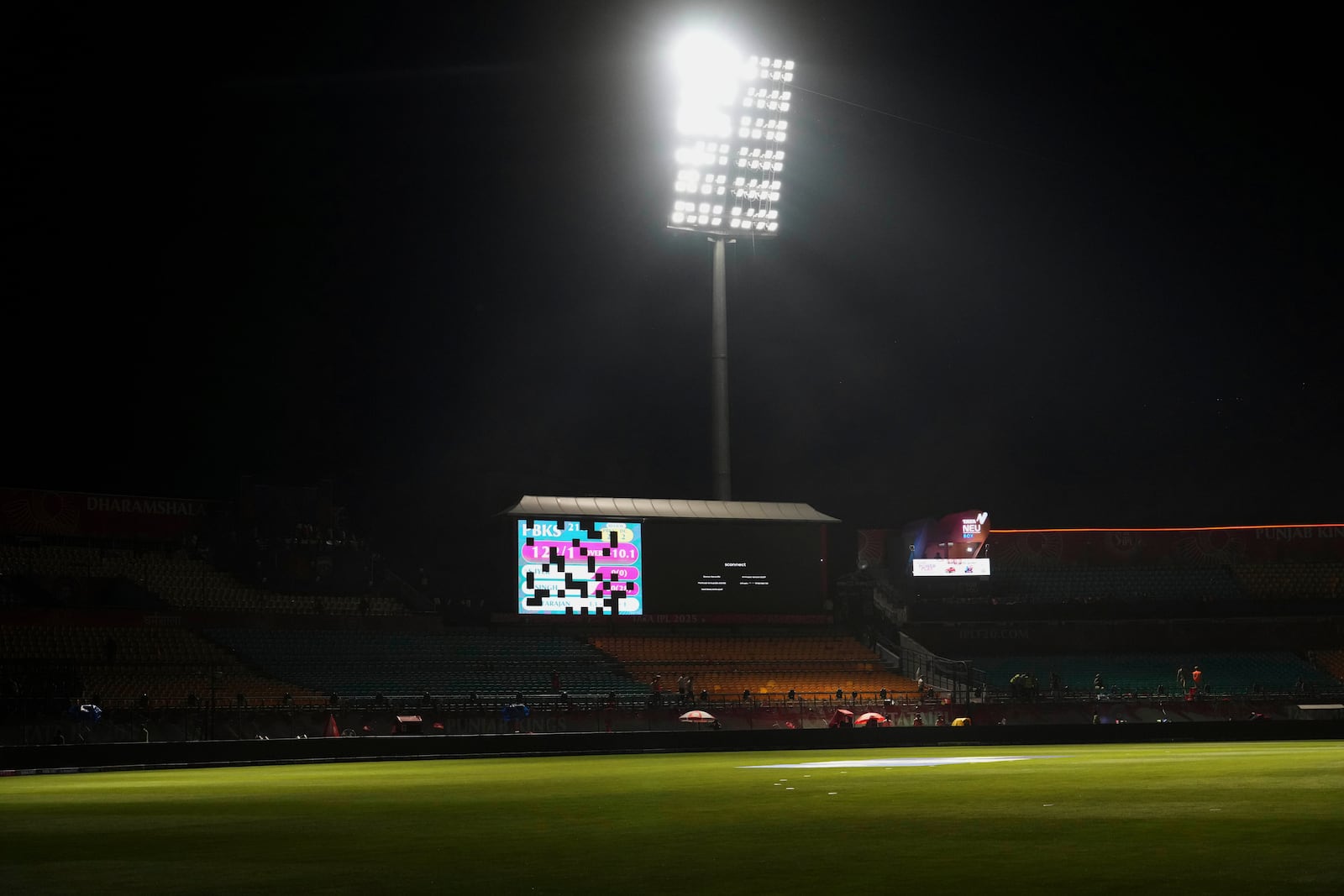 A display board is partially lit after the authorities asked to evacuate the stadium during the Indian Premier League cricket match between Punjab Kings and Delhi Capitals at Himachal Pradesh Cricket Association Stadium in Dharamshala, India, Thursday, May 8, 2025. (AP Photo/Ashwini Bhatia)