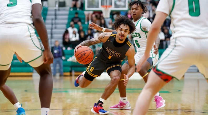 Springfield High School senior Tyron Barnes drives past Northmont junior Deuce Cortner during their game on Friday night at the Northmont High School Thunderdome. The Thunderbolts won 54-50. Michael Cooper/CONTRIBUTED