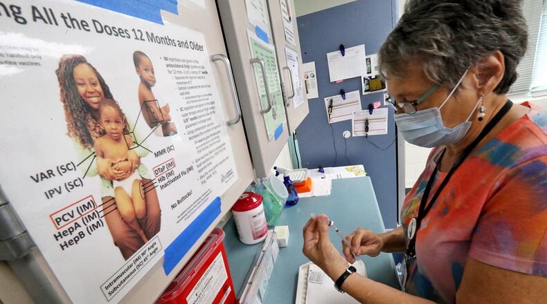Clark and Champaign health districts will host weekly COVID clinics through August. Here, a nurse at the Clark County Combined Health District prepares a vaccine.