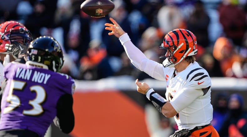 Cincinnati Bengals quarterback Joe Burrow, right, throws against the Baltimore Ravens during the first half of an NFL football game, Sunday, Dec. 14, 2025, in Cincinnati. (AP Photo/Carolyn Kaster)