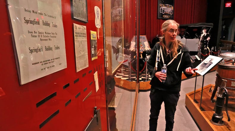 Kasey Eichensehr, senior curator at the Clark County Heritage Center Museum, explains how the museum staff is going to refresh some of the exhibit cases while the museum is closed in January. BILL LACKEY/STAFF