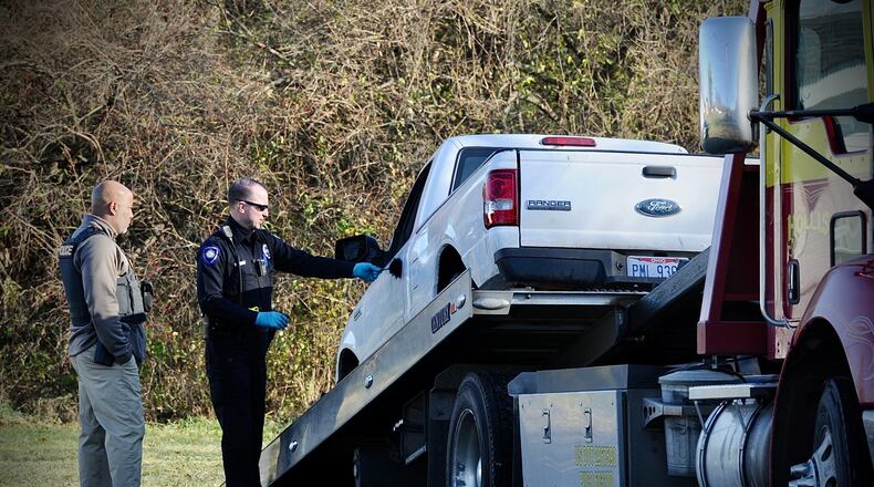 Huber Heights police dust for fingerprints on the driver's side of a white Ford Ranger stolen Tuesday, Nov. 30, 2021, from an Old Troy Pike auto shop after the suspect was involved in a kidnapping and fleeing from police. MARSHALL GORBY \STAFF