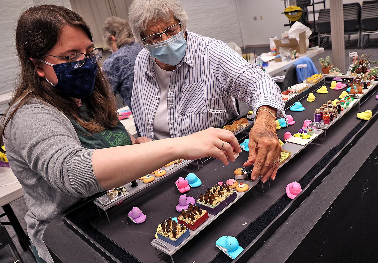 Natalie Fritz, left, Curator of Library and Archives
Clark County Historical Society at the Heritage Center, and volunteer Marguerite Brinkman work on the recreation of a historic photo of Myers Market using Peeps.  The Clark County Historical Society has been recreating scenes from Springfield's past with the sticky, marshmallow for 10 years but didn't make one last year due to COVID. When it's finished, the display can be seen in the lobby of the Clark County Heritage Center. BILL LACKEY/STAFF