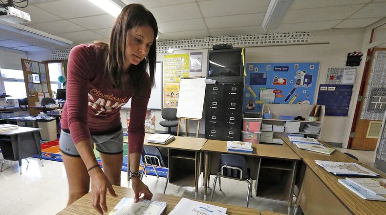 Beth Bertemes gets her first grade classroom at Miami View Elementary organized for the start of school next week. Bill Lackey/Staff