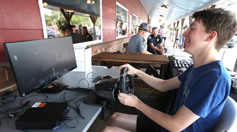 Vince Arnold, 17, laughes as he tries to comtrol a car on a drunk driving simulator during the 2021 Drive Sober or Get Pulled Over kickoff event at Young's Jersey Dairy. BILL LACKEY/STAFF