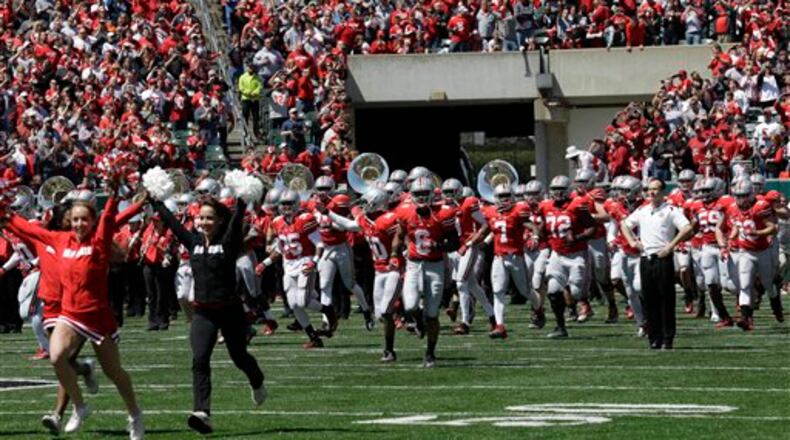 Cheerleaders lead the Ohio State Buckeyes onto the field at Paul Brown Stadium for their annual spring NCAA college football game, Saturday, April 13, 2013, in Cincinnati. (AP Photo/Al Behrman)