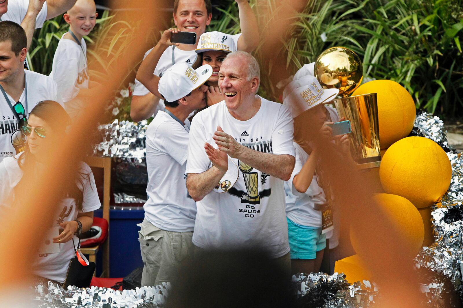 FILE - San Antonio Spurs head coach Gregg Popovich, center, claps during the basketball team's parade and celebration for their fifth NBA Championship, Wednesday, June 18, 2014, in San Antonio. (AP Photo/Michael Thomas, File)