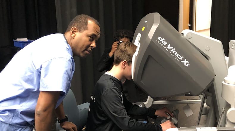 Graham Middle School student Josh Still tests a virtual operating system from Urbana Hospital with the guidance of surgeon Tedros Androm, MD. LUCAS GONZALEZ/STAFF