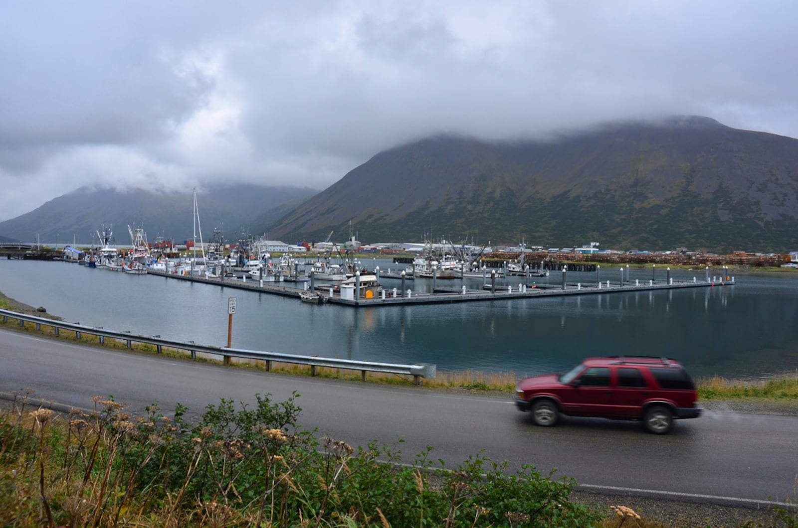 FILE - A driver passes the small boat harbor in King Cove, Alaska, Sept. 23, 2013. (James Brooks/Kodiak Daily Mirror via AP)