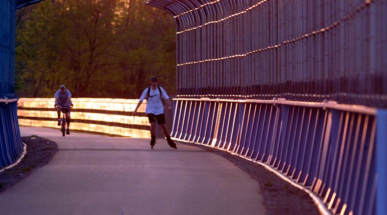 A cyclist and an in-line skater enter the bike path tunnel over the 675/35 interchange along Dayton-Xenia Rd. near Beavercreek at sunset.