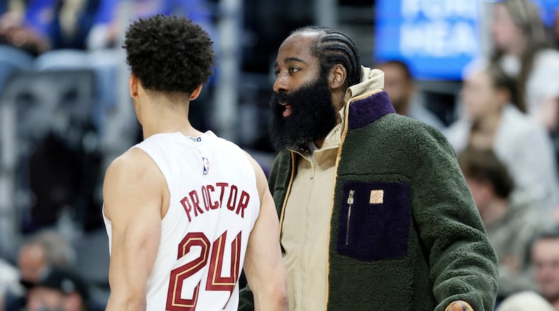 Cleveland Cavaliers guard James Harden, right, who is out injured with a right thumb fracture, talks with Cavaliers guard Tyrese Proctor (24) during the first half of an NBA basketball game Detroit Pistons, Friday, Feb. 27, 2026, in Detroit. (AP Photo/Duane Burleson)