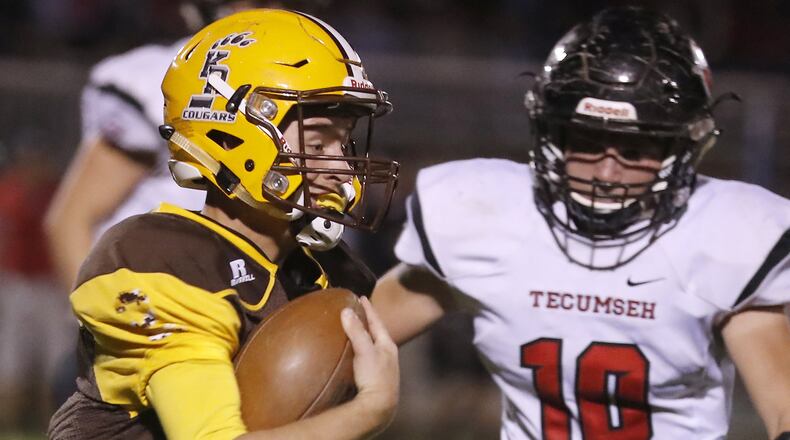 Kenton Ridge quarterback Dylan Lemen carries the ball as Tecumseh’s Andrew Betleyoun moves in for the tackle last season. Bill Lackey/Staff