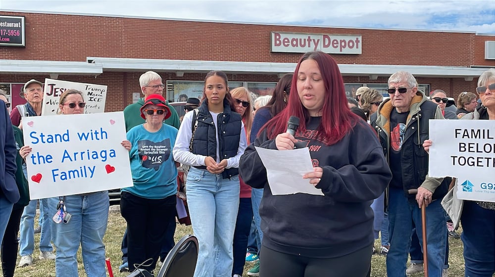 Lacy Arriaga, 37, of Springfield, (center) speaks during a press conference Saturday outside of the Southgate shopping center in Springfield. Local advocates gathered to show support for her family as her husband, Juan Arriaga Reyes, 45, was recently detained by U.S. Immigration and Customs Enforcement (ICE) following his annual check-in with the agency. He is being held at the Butler County Correctional Complex and is expected to be deported back to Mexico soon. SAM WILDOW/STAFF