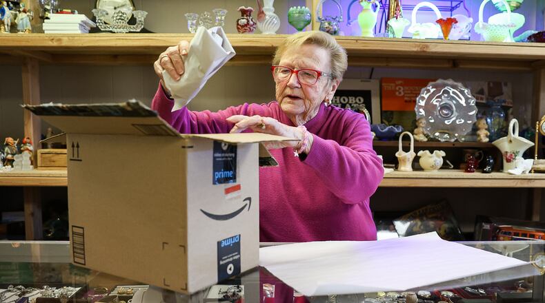 Gale Hutchinson, a co-owner of Pappy's Place in downtown Xenia, packs away an item on Monday. The antique store is moving from its current location on West Main Street to a larger location on East Main Street. BRYANT BILLING / STAFF