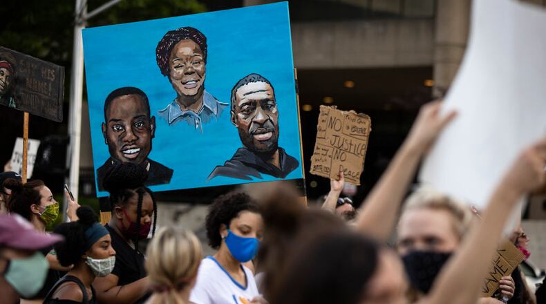 LOUISVILLE, KY - JUNE 05:   Protesters carry a painting of (L-R) Ahmaud Arbery, Breonna Taylor and George Floyd while marching on June 5, 2020 in Louisville, Kentucky. Protests across the country continue into their second weekend after recent police-related incidents resulting in the deaths of African-Americans Breonna Taylor in Louisville and George Floyd in Minneapolis, (Photo by Brett Carlsen/Getty Images)