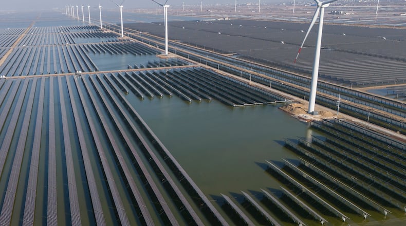 FILE - Wind turbines operate along a solar farm near Weifang in eastern China's Shandong province on March 22, 2024. (AP Photo/Ng Han Guan, File)