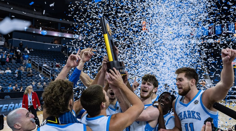The Nova Southeastern men's basketball team -- which includes Lakota East grad Alex Mangold (right) and Kenton Ridge grad Tyler Eberhart -- hoists the trophy after it beat Cal State Dominguez Hills to claim the Division II national title on March 28 in Evansville, Indiana. CONTRIBUTED PHOTO