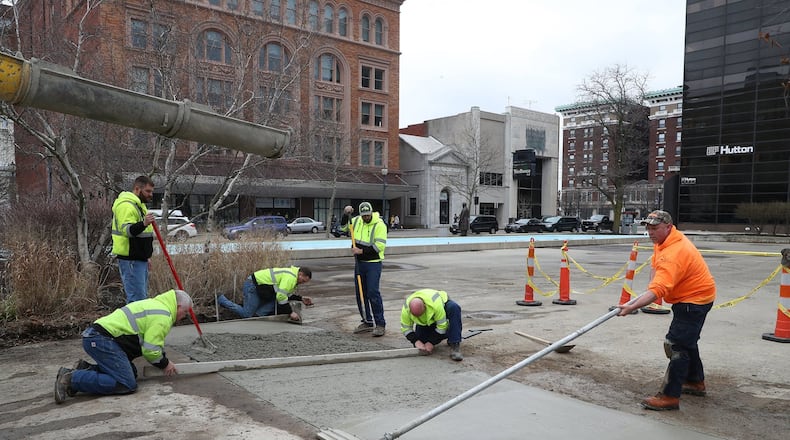 Workers finish a concrete ramp on the City Hall Plaza Wednesday that will allow food trucks to park on a lower section of the plaza along the Main Street fountain. BILL LACKEY/STAFF