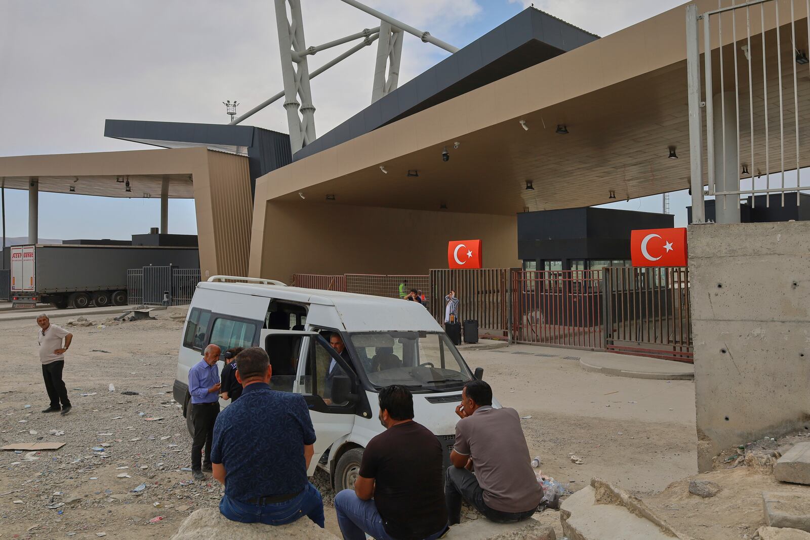 People wait after crossing from Iran into Turkey at Gurbulak Bazargan border post, in Gurbulak, Turkey, Monday, June 16, 2025. (AP Photo/Kadir Cesur)