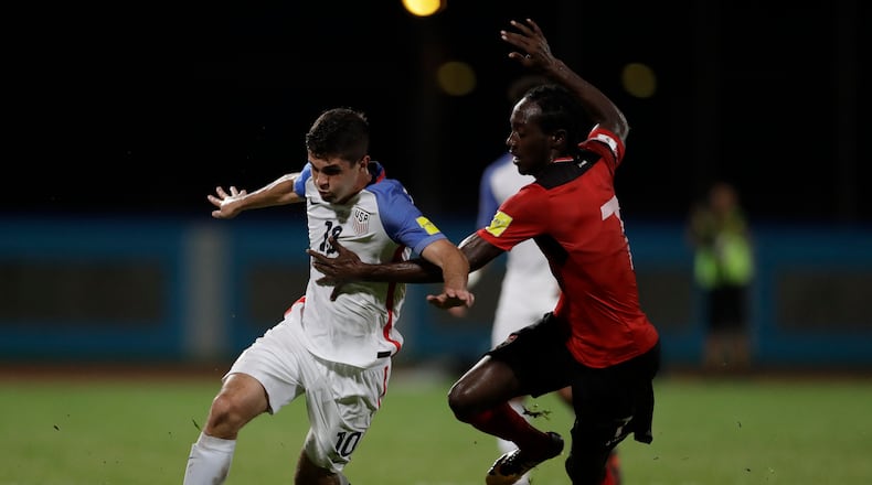United States’ Christian Pulisic, left, fight for the ball with Trinidad and Tobago’s Nathan Lewis during a 2018 World Cup qualifying soccer match in Couva, Trinidad, Tuesday, Oct. 10, 2017. (AP Photo/Rebecca Blackwell)