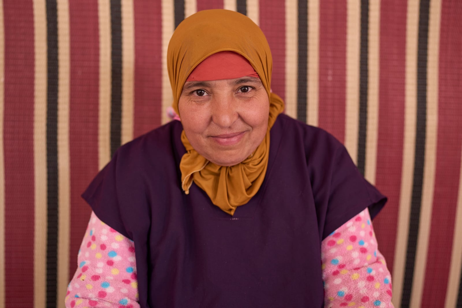 Rabiaa Reshmayn, who works at a cooperative that extracts and produces argan oil and products, poses for a portrait, in Essaouira, Morocco, Thursday, May 22, 2025. (AP Photo/Mosa'ab Elshamy)