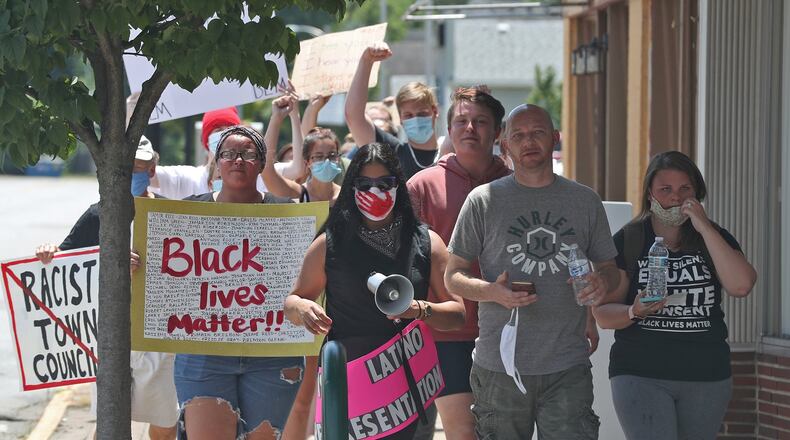 Black Lives Matter demonstrators march through New Carlisle Saturday. BILL LACKEY/STAFF