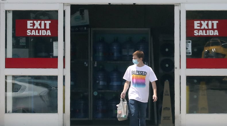 A customer walks out of Lowes in Springfield with a mask. BILL LACKEY/STAFF