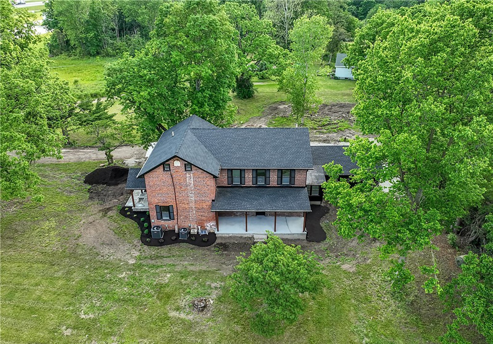 The rear of this brick two story featues a covered porch and there is a pond on the property. CONTRIBUTED