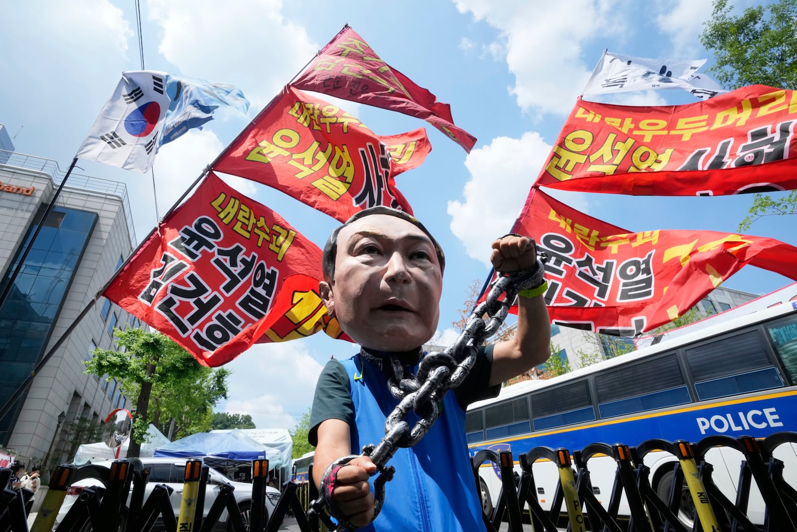 A protester wears a mask of former South Korean President Yoon Suk Yeol during a rally supporting a hearing to review a special prosecutor's request for his arrest near the Seoul Central District Court in Seoul, South Korea, Wednesday, July 9, 2025. The letters read "Yoon Suk Yeol sentenced to death." (AP Photo/Ahn Young-joon)