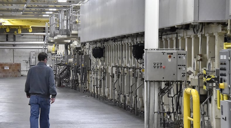 A Weidmann Electrical Technology Corp. employee walks along the giant paper machine in the company’s Urbana factory. The company is one of several that are participating in the new Champaign Economic Partnership, which seeks to bring more jobs to the county and support local businesses. Bill Lackey/Staff