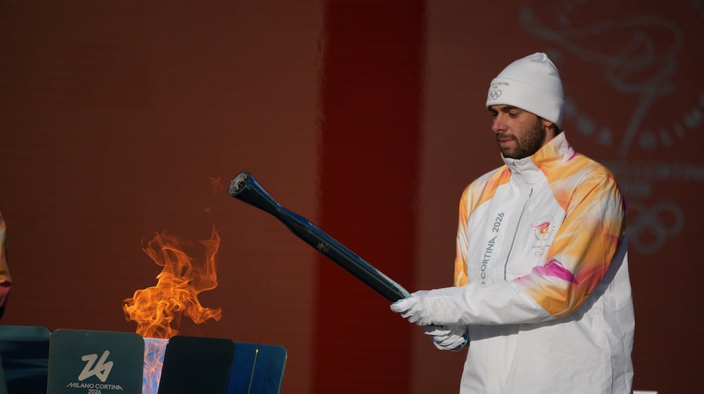 Italian swimmer Gregorio Paltrinieri lights the 2026 Milan Cortina Winter Olympics torch in Rome as it begins its journey through Italy, Saturday, Dec. 6, 2025, a journey that will conclude in Milan in February 2026. (AP Photo/Andrew Medichini)