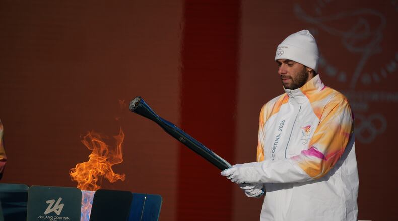 Italian swimmer Gregorio Paltrinieri lights the 2026 Milan Cortina Winter Olympics torch in Rome as it begins its journey through Italy, Saturday, Dec. 6, 2025, a journey that will conclude in Milan in February 2026. (AP Photo/Andrew Medichini)