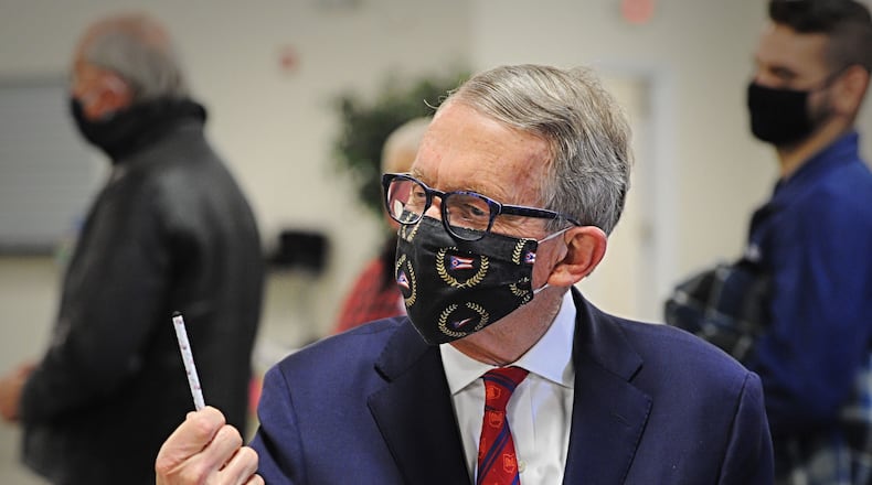 Governor Mike DeWine checks out the stylus that he was given for voting on Tuesday at the Cedarland Event Center.